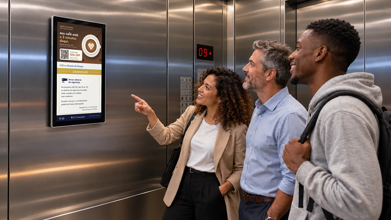 Moradores vendo um comunicado do condomínio na tela digital da Plena no elevador